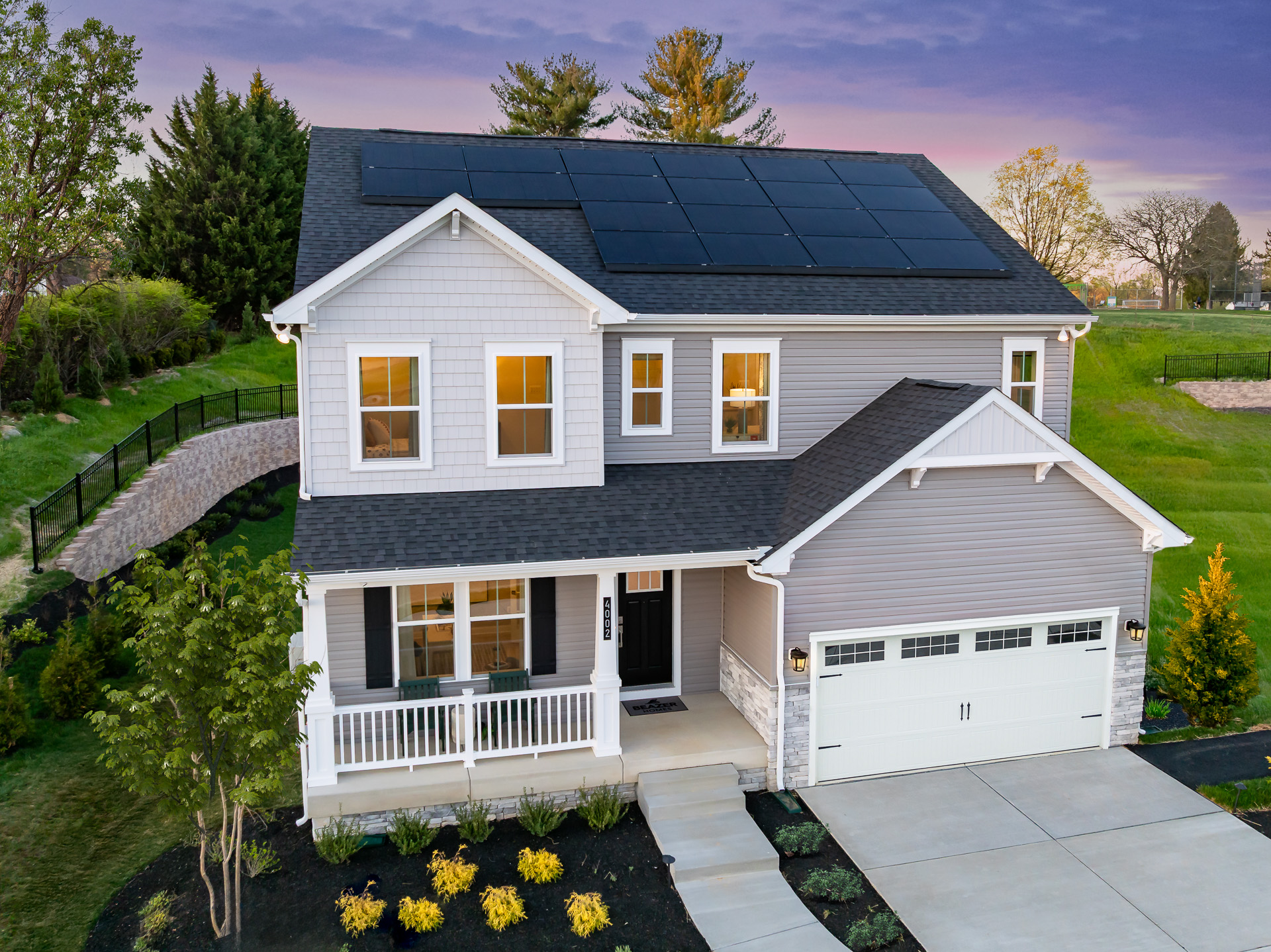 two-story home at dusk with solar panels on the roof