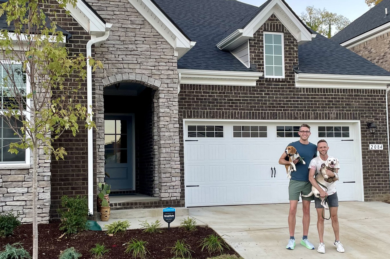 Couple with their dogs outside of their new home