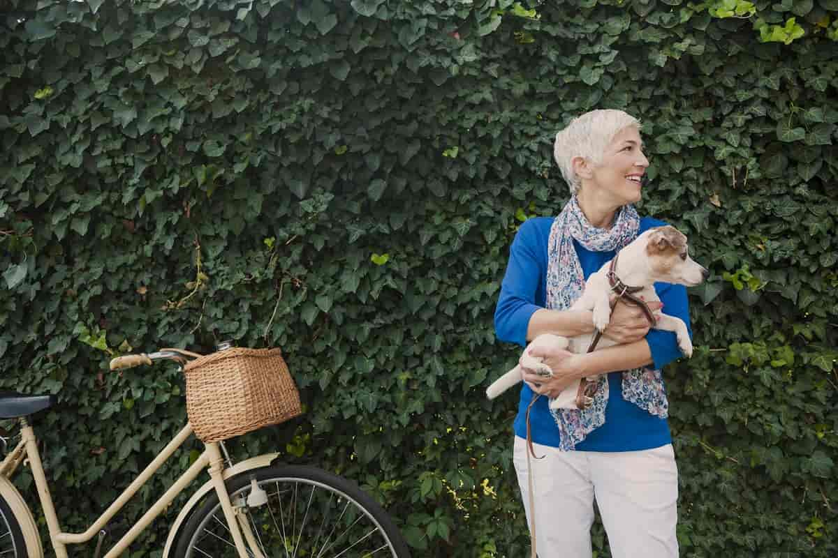 Older woman smiling and holding a dog